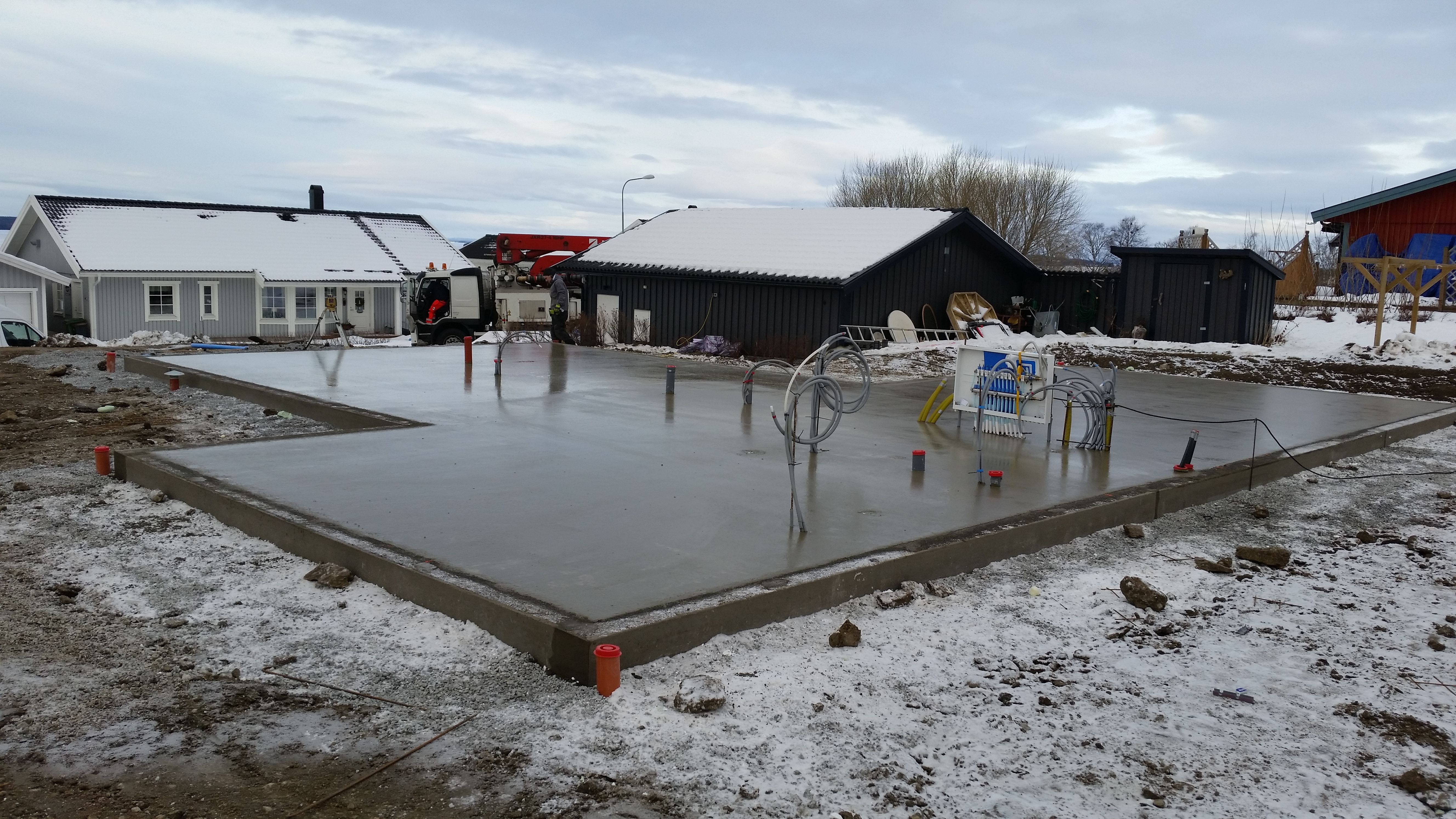 Gjuten betonplatta med rör och kablar som sticker upp